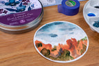 A round watercolor paper sample showing a painted landscape. Hahnemuhle 140lbs- 5 inches