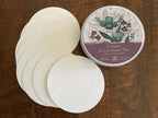 A set of round off-white watercolour paper circles fanned out. Hahnemuhle round tin container, 140lbs, 5 inches.